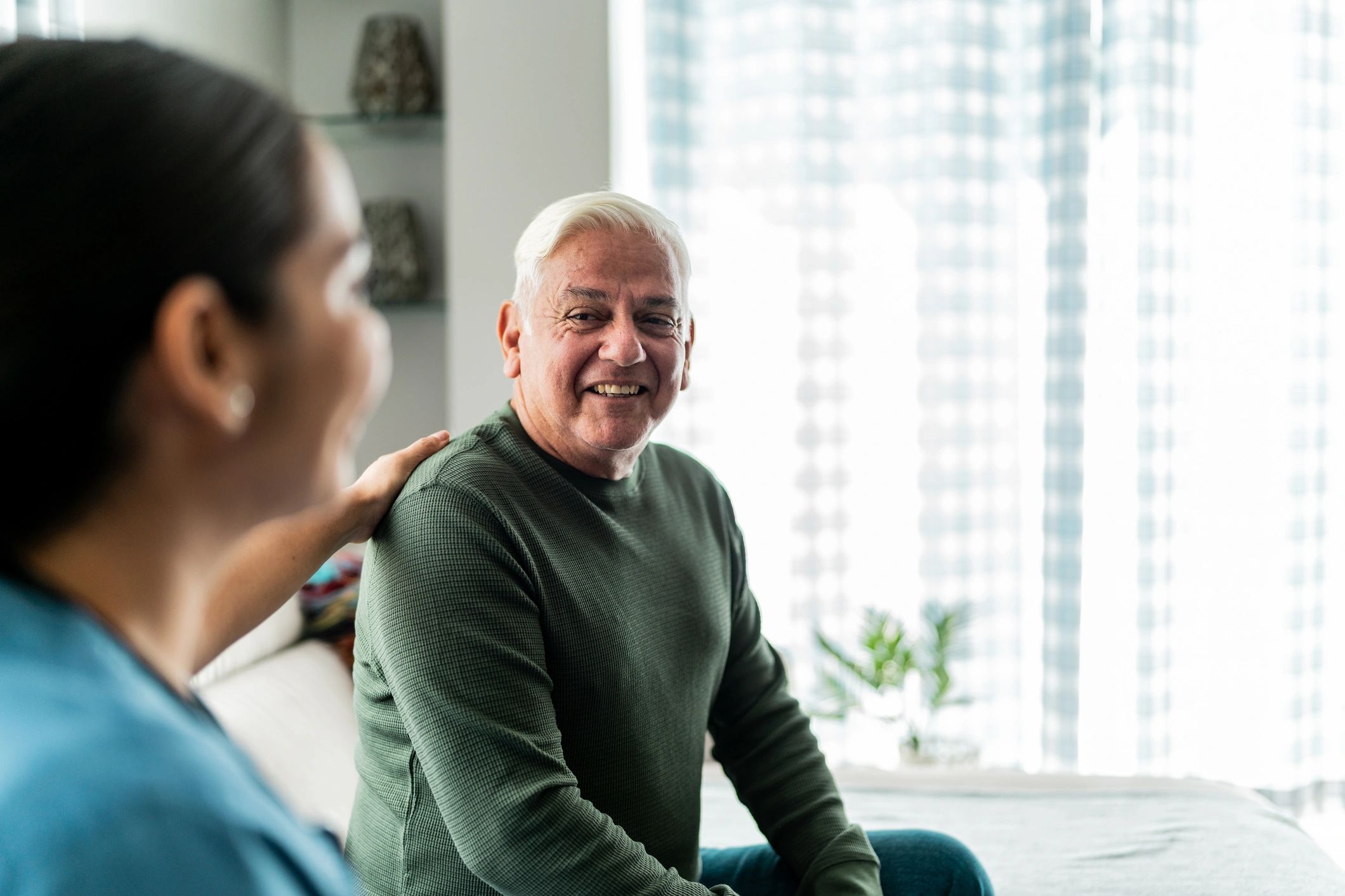 Senior client speaking with a home healthcare professional during an in-home visit